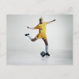 Female soccer player preparing to kick soccer postcard
