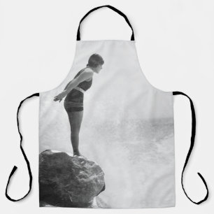 Female swimmer on rock above crashing surfvintage, apron