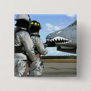 Firefighters deploy a fire hose during a drill 15 cm square badge