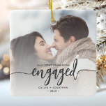 First Christmas Engaged Custom Photo Grey Script Ceramic Ornament<br><div class="desc">Commemorate your engagement with this beautiful modern keepsake ornament. The charcoal grey text reads "Our first Christmas engaged, " with the word "engaged" in elegant calligraphy script with decorative swashes before and after. Replace the sample image with your favourite photo, and add your names and the year. A white gradient...</div>