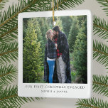 First Christmas Engaged | Minimal Engagement Photo Ceramic Ornament<br><div class="desc">A stylish minimal photo holiday christmas tree ornament with classic typography "Our first christmas engaged" in black on a clean simple minimalist white background. The photo, greeting and name can be easily customized for a personal touch. A simple, minimalist and contemporary christmas design to announce your engagement to your loved...</div>