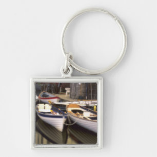 Fog surrounds four boats docked. key ring
