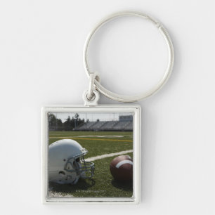 Football and football helmet on football field key ring