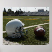 Football and football helmet on football field