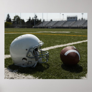 Football and football helmet on football field poster
