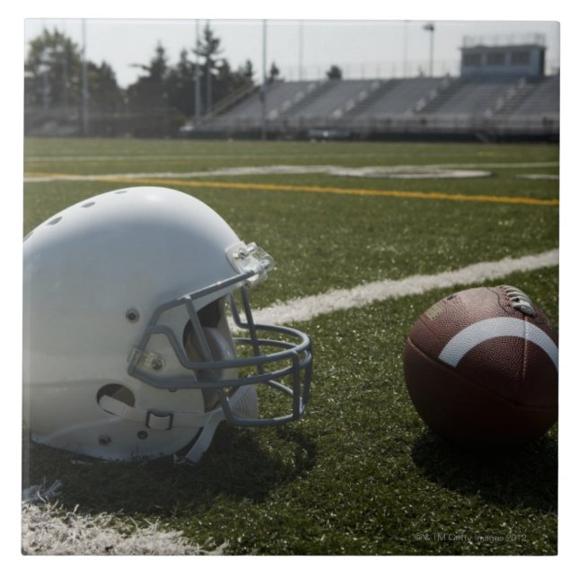 Football and football helmet on football field tile (Front)