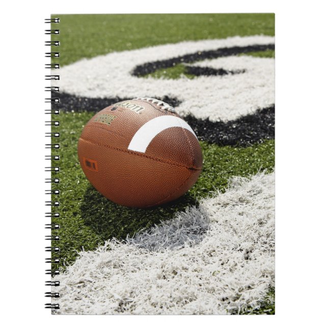 Football at goal line on football field, notebook (Front)