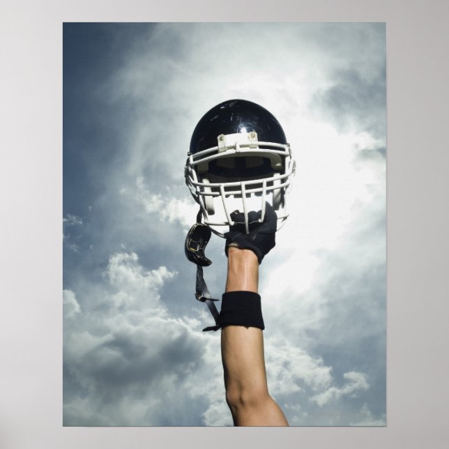 Football player holding helmet in air poster (Front)