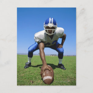football player playing on a football field postcard