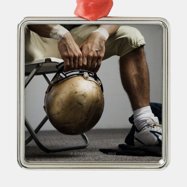 Football player sitting in locker room metal tree decoration (Front)
