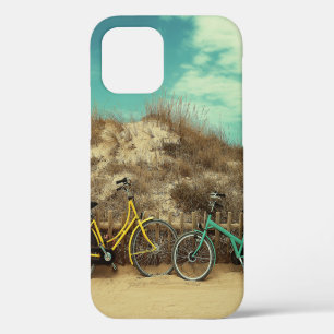 Four assorted-colour commuter bikes near hill at d iPhone 12 case