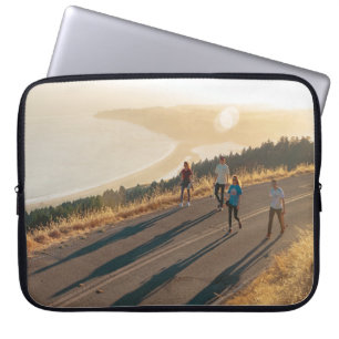 Four men and women walking on roadway near body of laptop sleeve