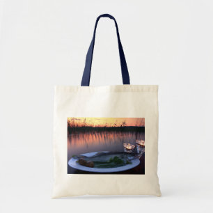 Fresh fish catch on a plate with vegetables tote bag