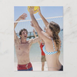 Friends playing volleyball on beach postcard