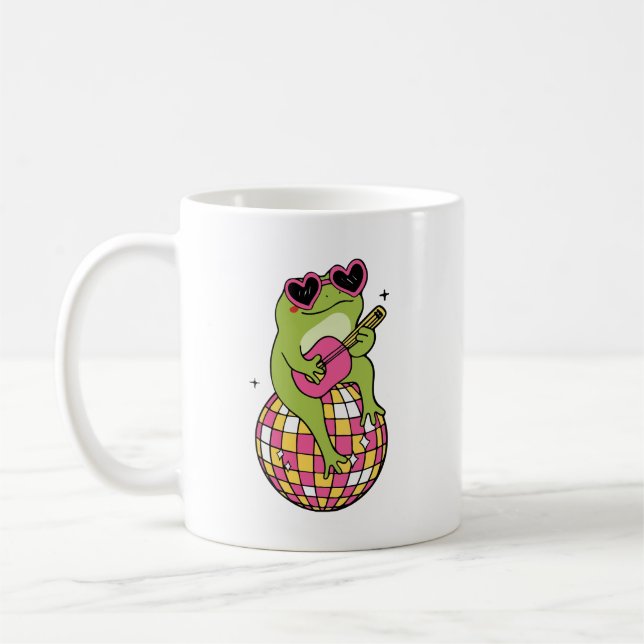 Frog sitting on dance ball playing guitar  coffee mug (Left)