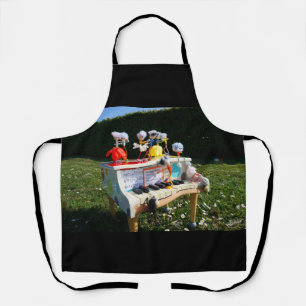 Fubbies on the piano making and dancing music. apron