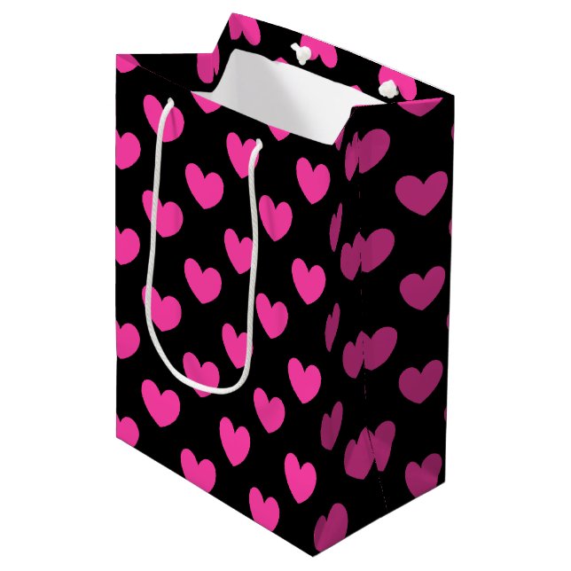 Fuchsia pink polka hearts on black medium gift bag (Front Angled)