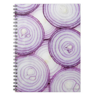 Full frame of sliced red onion, on white notebook