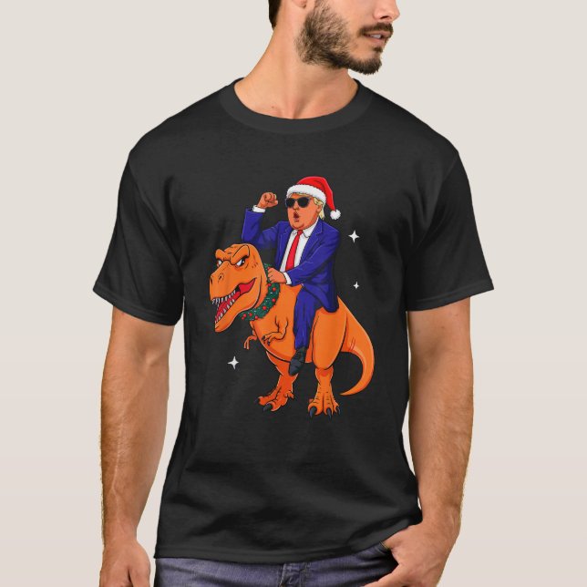 Funny Christmas Trump Riding Dinosaur T Rex Christ T-Shirt (Front)