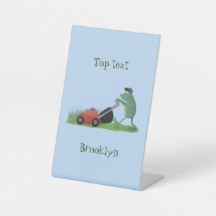Funny green frog mowing lawn cartoon pedestal sign