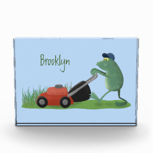 Funny green frog mowing lawn cartoon photo block