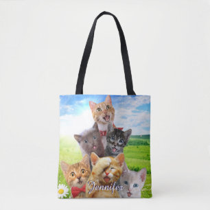 Funny kittens in green field. tote bag