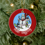 Funny Snowman Merry Christmas! Skiing Cartoon Ceramic Tree Decoration<br><div class="desc">A jolly snowman on a ceramic ornament for your Christmas tree. Use "Personalise this template" to tweak the "Merry Christmas!" text and create a unique, customised gift. Featuring a cute snowman with a carrot nose and coal eyes, dashing through the snow on skis, in woolly winter hat and tartan scarf,...</div>