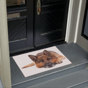 German shepherd lying down on a white background doormat