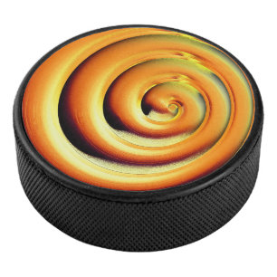 Giant shiny orange spiral over black hockey puck