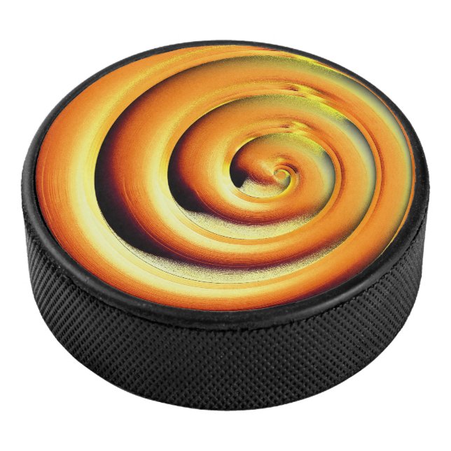 Giant shiny orange spiral over black hockey puck (3/4)