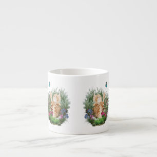 Ginger kitten playing with a butterfly espresso cup