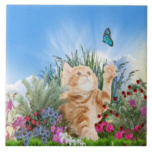 Ginger kitten playing with a butterfly tile