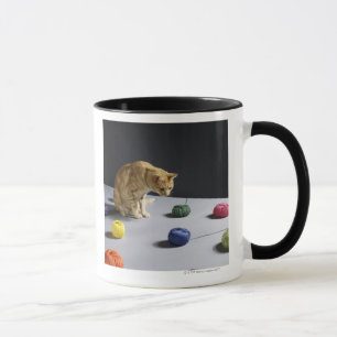 Ginger tabby cat sitting on table mug
