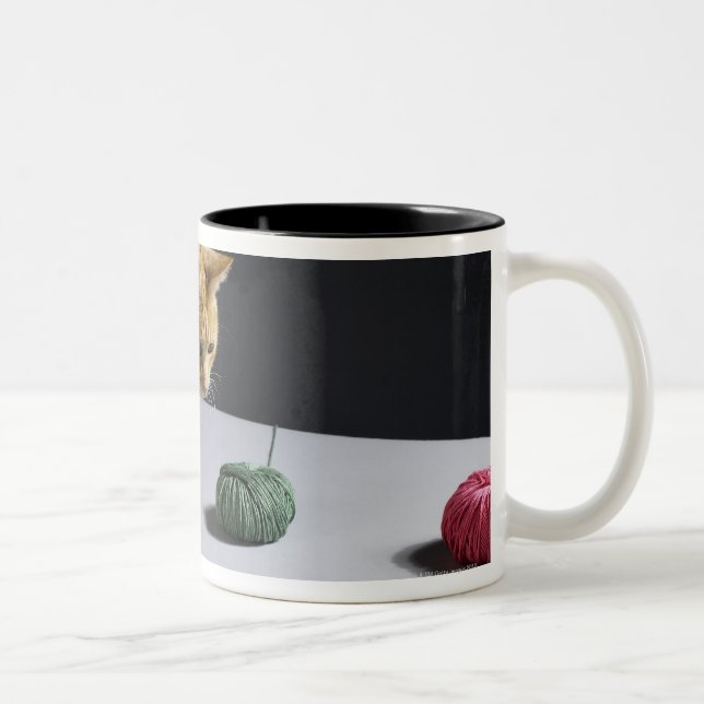 Ginger tabby cat sitting on table Two-Tone coffee mug (Right)