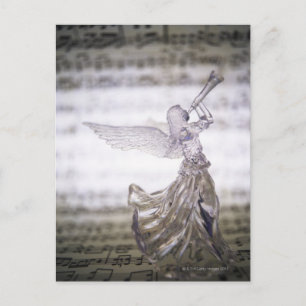 Glass angel playing trumpet and image of sheet postcard