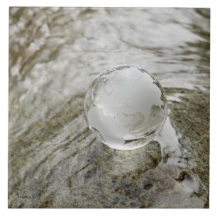 Glass globe on the water stream tile