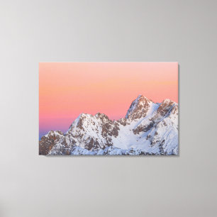 Glowing sunset sky and snowy mountains canvas print