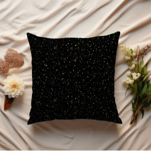 Gold glitter and sparkles on black cushion