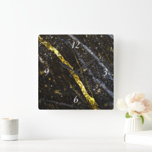 Gold sparkly line on black rock with clock face