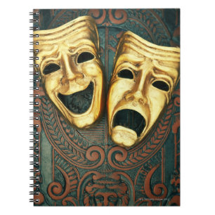 Golden comedy and tragedy masks on patterned notebook