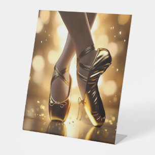 Golden Elegance: Ballerina Shoes on Gold Bokeh Pedestal Sign