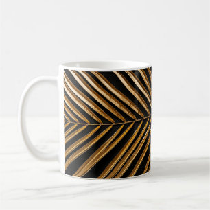 Golden painted date palm leaf closeup on abstract coffee mug