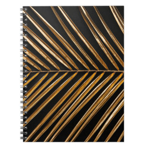 Golden painted date palm leaf closeup on abstract notebook
