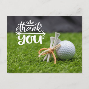 Golf ball and tee are on green grass thank you  postcard