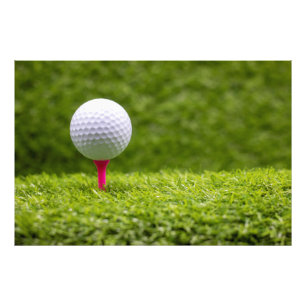 Golf ball is on pink tee on green grass background photo print