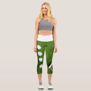 Golf ball with putter on green grass capri leggings