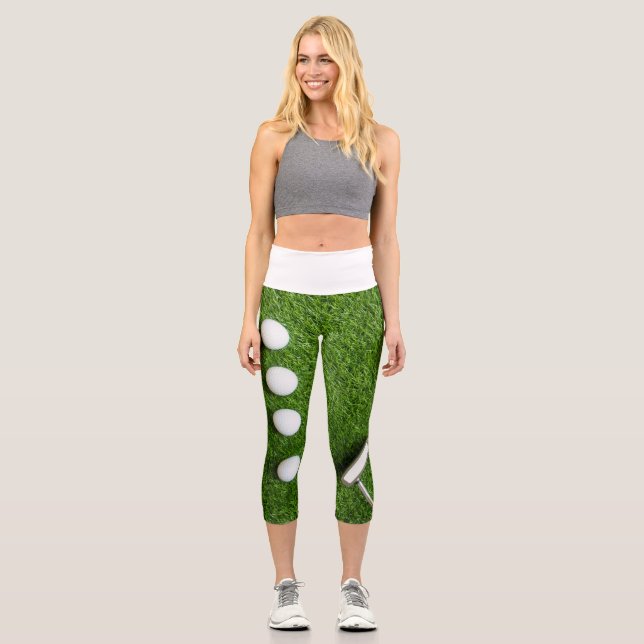 Golf ball with putter on green grass capri leggings (Front)