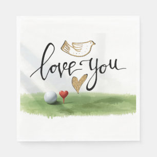 Golf ball with red heart tee on green grass napkin