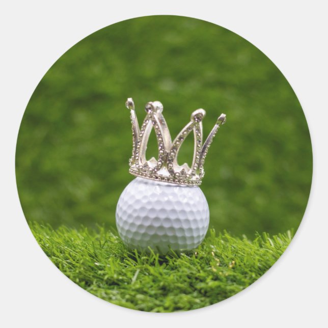 Golf ball  with silver crown are on green grass  classic round sticker (Front)