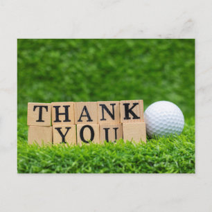 Golf ball with thank you word on green grass postcard